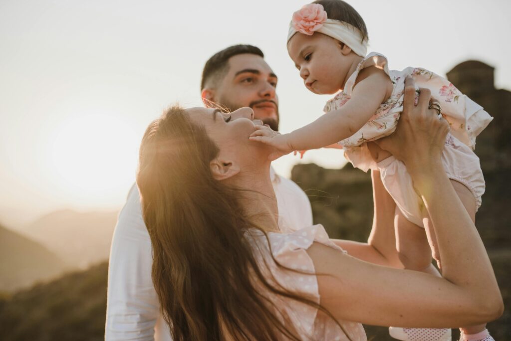 A touching moment of a family enjoying togetherness in a scenic outdoor setting during sunset.